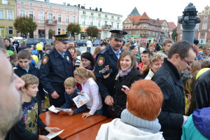 Policjanci rozdają ulotki dzieciom i dorosłym na miejskim wydarzeniu w 2012 roku.