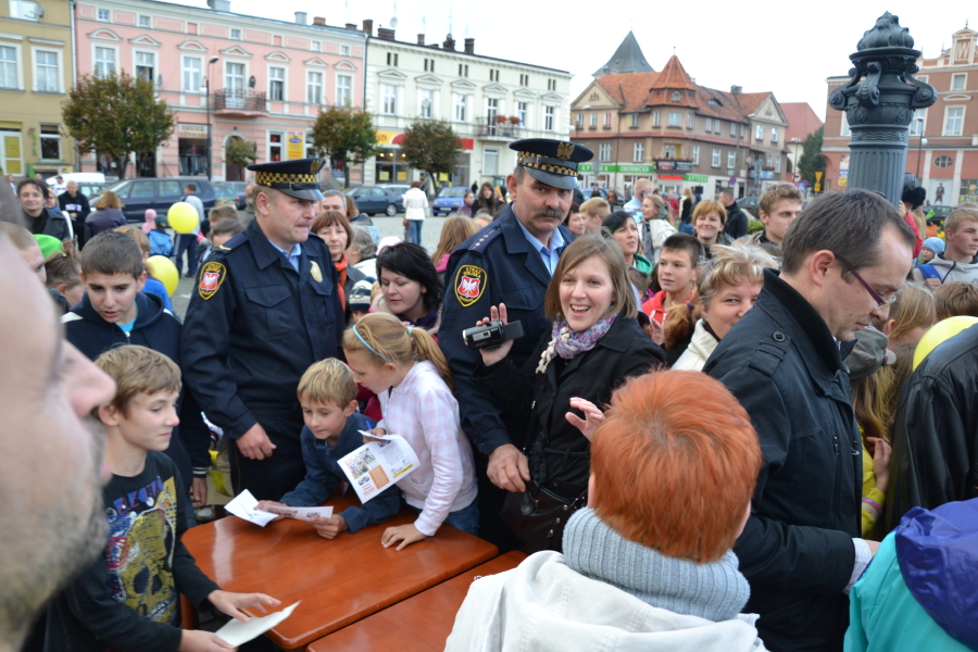 Policjanci rozdają ulotki dzieciom i dorosłym na miejskim wydarzeniu w 2012 roku.