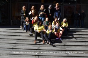 Grupa osób siedzi i stoi na stopniach schodów w Poznaniu, 17 października 2012 roku.
