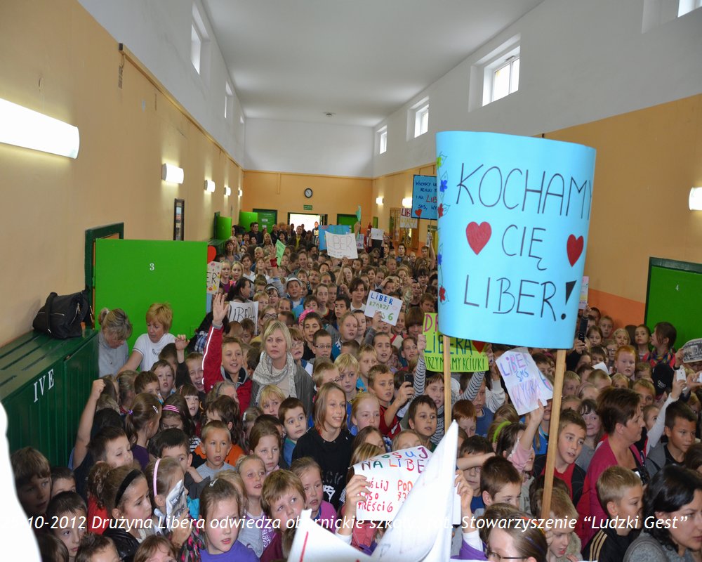 Grupa dzieci wita Liberę, trzymając transparent z napisem „Kocham Cię Libera!”.