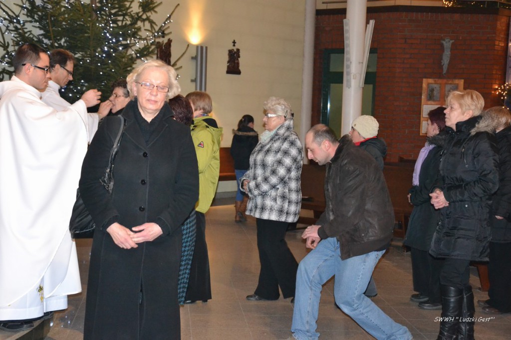 Uczestnicy ceremonii wewnątrz budynku, w tle widoczna choinka i fragment dekoracji świątecznych.