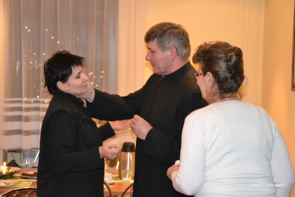 Trzy osoby uczestniczą w ceremonii.