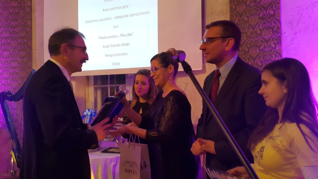 Mężczyźni w garniturach prezentują listę na ekranie podczas uroczystego spotkania Noworocznego w 2017 roku.