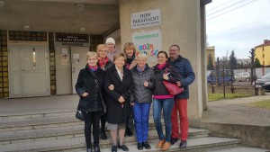 Grupa wolontariuszy stoi przed budynkiem Domu Parafialnego podczas Dnia Skupienia Wielkopostnego.